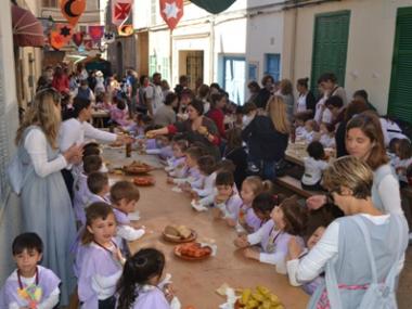 Els escolars comencen la festa amb un pa amb oli medieval