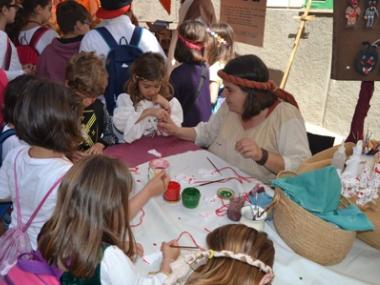 Els escolars comencen la festa amb un pa amb oli medieval